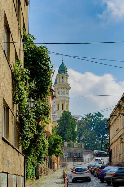 Alte Straße in Uzhgorod. Eines der Gebäude baut grüne Trauben an. Straffung. Menschen, Autos und Zimmer sind Markenautos verschwommen. — Stockfoto