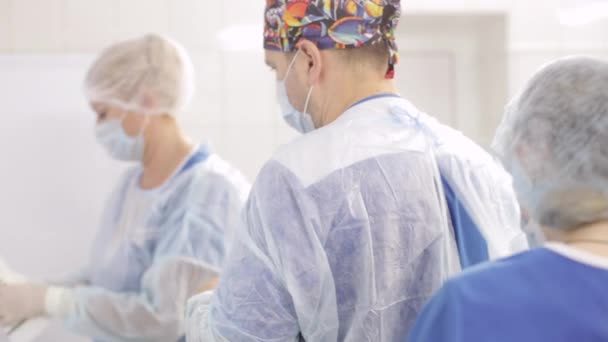 Доктор кладе медичну рукавичку в операційну кімнату — стокове відео
