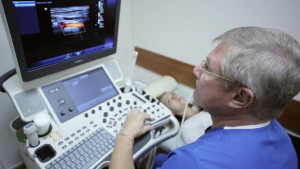 Médico fazendo uma ultrassonografia do pescoço dos pacientes no hospital — Vídeo de Stock