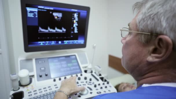 Доктор використовує ультразвукову машину для сканування пацієнта жінки — стокове відео