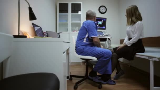 Orvos és a beteg ultrahang diagnosztikai szobában beszél — Stock videók