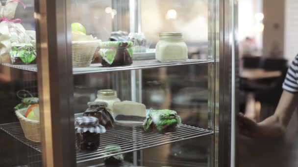 Waiter open the door of fridge and take a pot of jam for customers — Stock Video