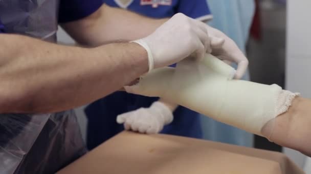 Médecin étendu sur le gypse sur la main patiente — Video