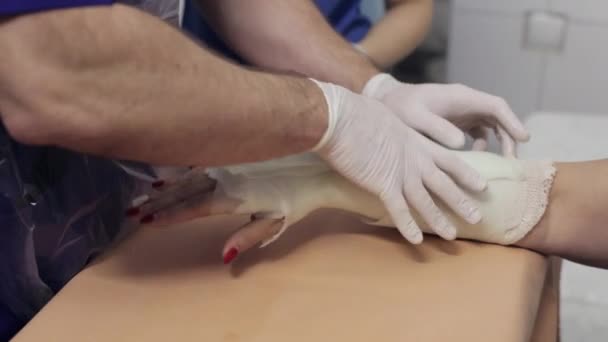 Médecin étendu sur le gypse sur la main patiente 