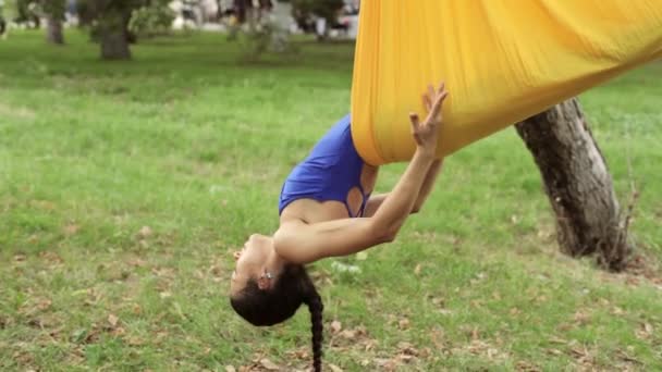 Anti-gravità Yoga, donna che fa esercizi di yoga con amaca nel parco — Video Stock