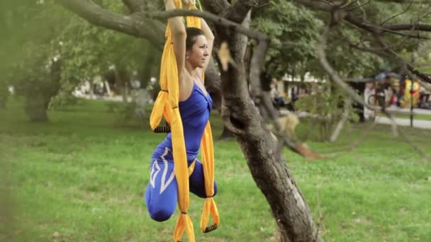 Anti-gravità Yoga, donna che fa esercizi di yoga con amaca nel parco — Video Stock