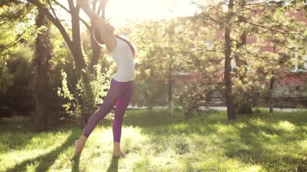 Ejercicios de yoga y pilates en el césped en la mañana soleada . — Vídeos de Stock