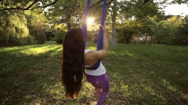 Practicante de yoga aéreo se estira mientras está suspendida en la hamaca . — Vídeos de Stock