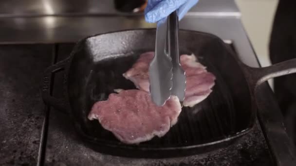 Due bistecche di filetto che friggono su una pentola di piastra calda fumante — Video Stock
