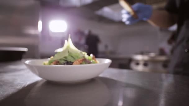 Chef adding toasts to fresh salad with lettuce, shrimps and cheeze. — Stock video