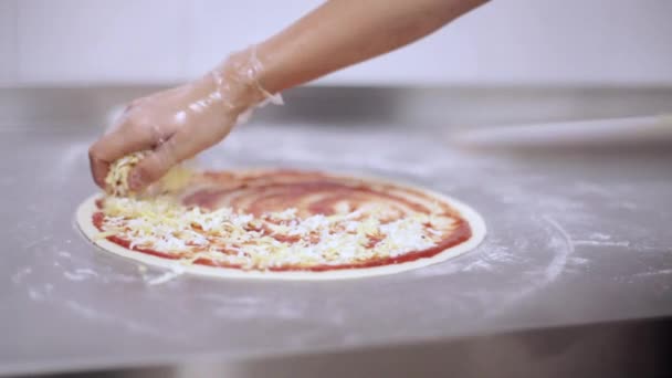 Chef-kok Italiaanse pizza maken. Handen van chef-kok Voeg de ingrediënten in de pizza — Stockvideo