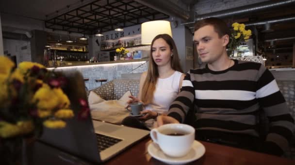 Woman and man works on computer in cafe Stock Video