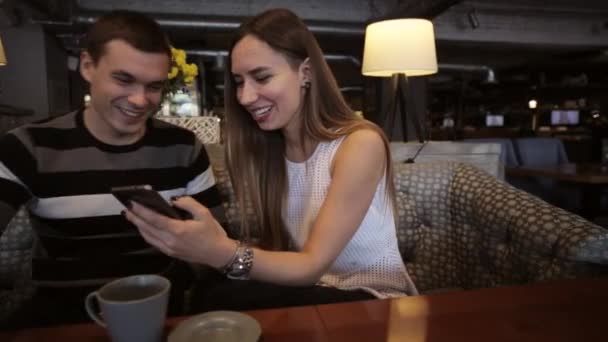 有吸引力的年轻夫妇说，在咖啡厅使用智能手机 — 图库视频影像