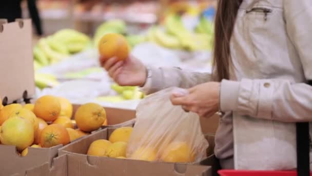 Kvinnan att välja orange frukt grönsaker snabbköpet — Stockvideo