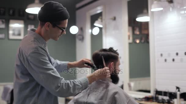 Barber zastřihne vlasy klienta s nůžkami — Stock video