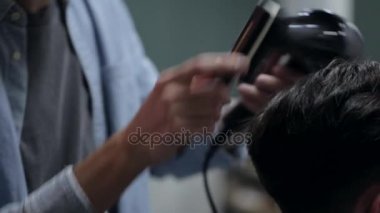 Kuaför Saç erkek müşteri ile saç kurutma makinesi ve tarak, yakın çekim için kurur.