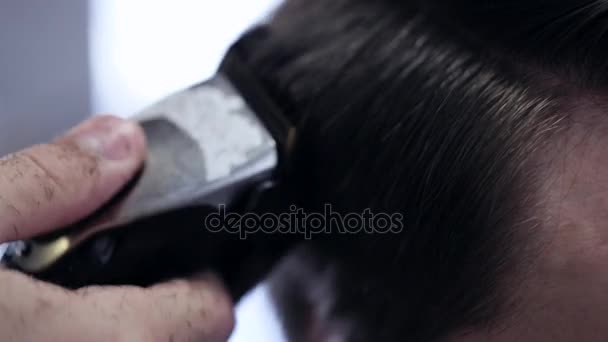 Tukang cukur membentuk potongan rambut pria kulit putih dengan pisau cukur listrik di salon, close-up . — Stok Video