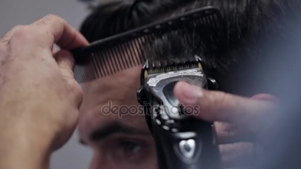 Barbier forme homme blanc coupe de cheveux avec rasoir électrique au salon de coiffure, gros plan . — Video
