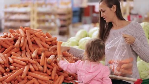 Anya és lánya, zöldségek, míg bevásárlás szupermarketben kiválasztása — Stock videók