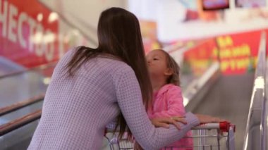 Anne ile kızı süpermarkette sonraki kata yürüyen merdiven sürme arabası.
