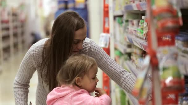 Jovem mãe com bebê filha compras no supermercado — Vídeo de Stock