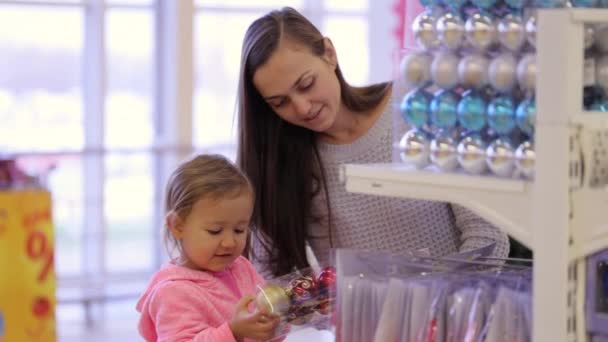 Jovem mãe atraente com compras de menina decorar para a árvore de Natal . — Vídeo de Stock