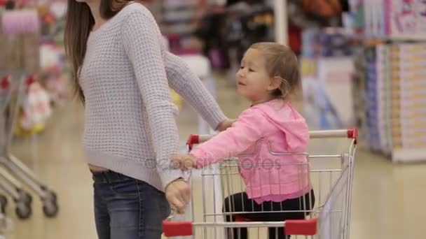 Giovane madre attraente con bambina compra decorare per l'albero di Natale . — Video Stock