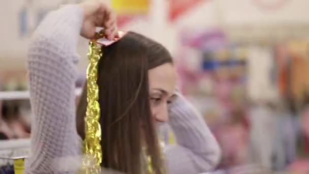 Moeder en dochter met plezier met versieren voor kerstboom bij supermarkt. — Stockvideo