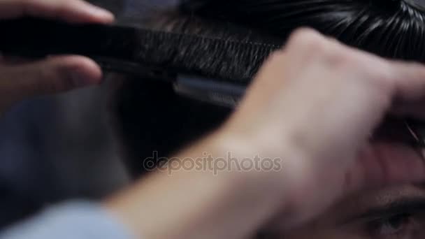 Peluquero haciendo corte de pelo de hombre barbudo atractivo en la barbería . — Vídeos de Stock