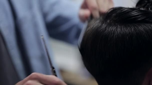 Peluquero haciendo corte de pelo de hombre barbudo atractivo en la barbería . — Vídeos de Stock