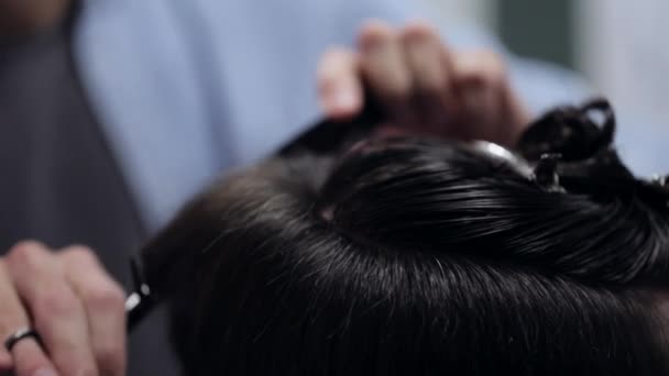 Junge hübsche Friseurin macht Haarschnitt eines attraktiven bärtigen Mannes im Friseursalon — Stockvideo