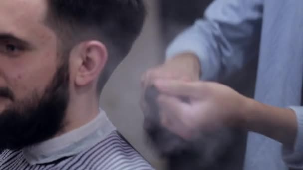 Manlig Frisör göra en frisyr för skäggiga klienten och använder en Talk på barbershop — Stockvideo