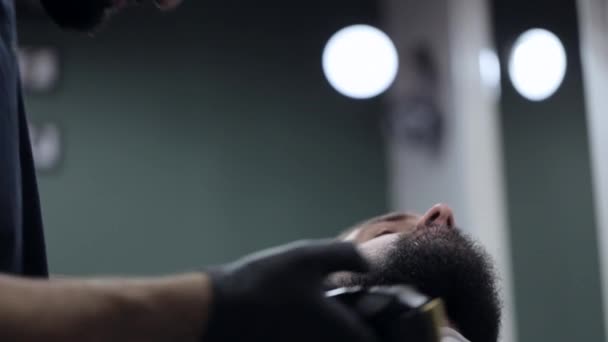 在一家理发店的电动剃须刀的男性理发师切割胡子. — 图库视频影像