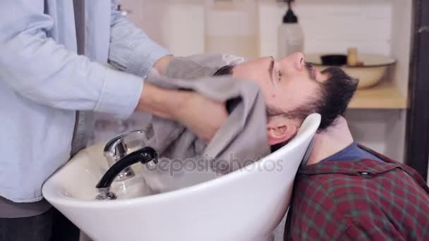 Чоловічі перукарські серветки промиті волосся красивого чоловіка клієнта з рушником в перукарні — стокове відео