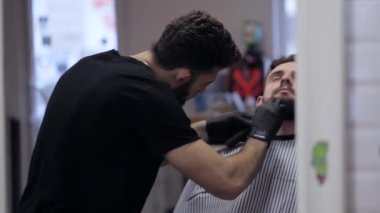 Erkek bir istemci kesme sakal tıraş kullanarak bir Kuaför Close-Up.