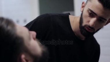 Erkek bir istemci kesme sakal tıraş kullanarak bir Kuaför Close-Up.