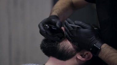 Erkek bir istemci kesme sakal tıraş kullanarak bir Kuaför Close-Up.