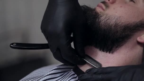 Barbeiro barba a barba do cliente na barbearia — Vídeo de Stock