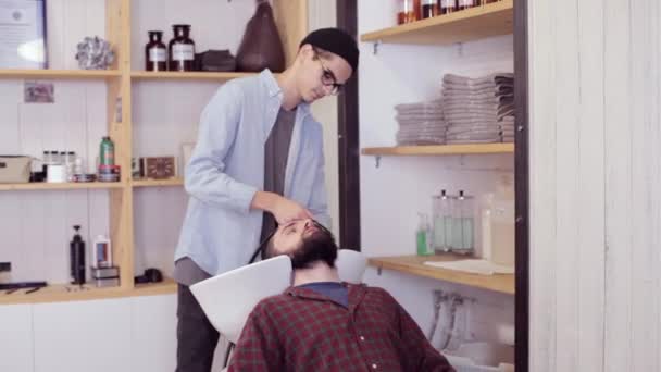 Hombre peluquero lavado de cabello masculino en la barbería — Vídeo de stock