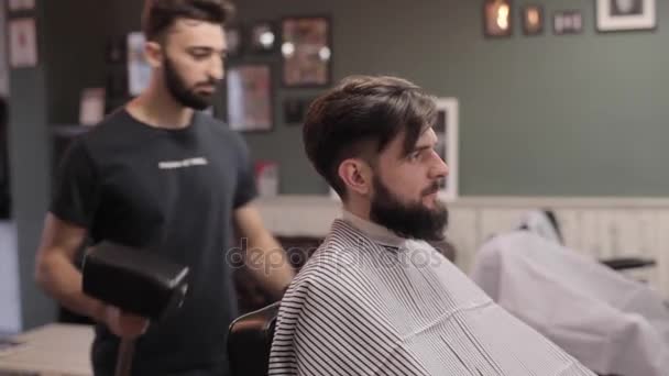 Barbeiro preparando seu cliente para uma barba em uma barbearia vintage . — Vídeo de Stock