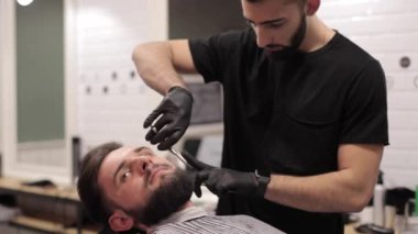 Bir kuaför dükkanında makasla kesme sakal berber.