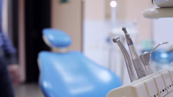 Herramientas del dentista y el paciente se sienta en la silla del dentista — Vídeos de Stock