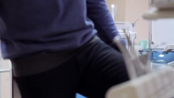 Paciente do sexo masculino se senta na cadeira do dentista — Vídeo de Stock