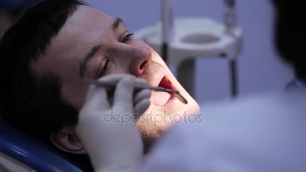 Дантист делает инъекции своему пациенту в стоматологической клинике — стоковое видео