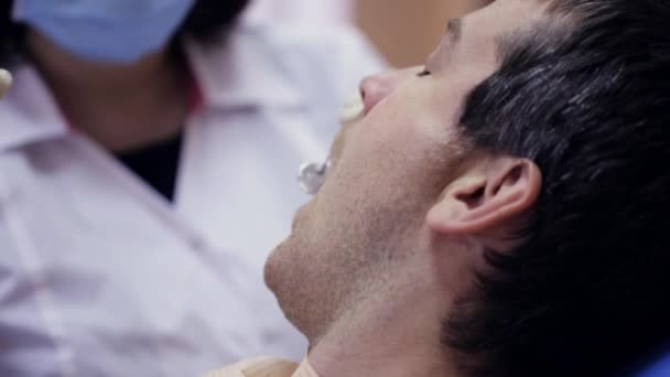 Tandarts injecteert zijn patiënt in de tandheelkundige kliniek — Stockvideo