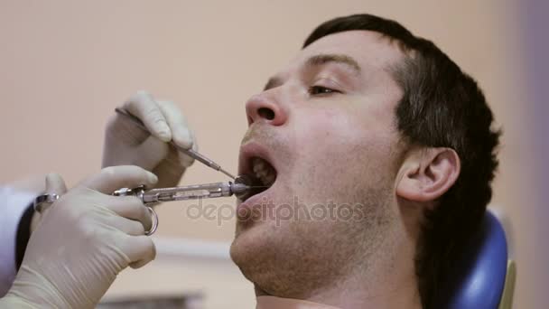 Стоматолог робить ін'єкції своєму пацієнту в стоматологічній клініці — стокове відео