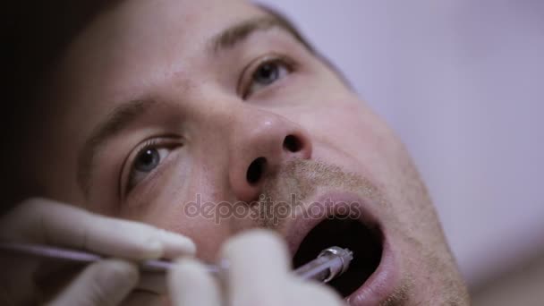 Dentista inyectando a su paciente en clínica dental — Vídeo de stock