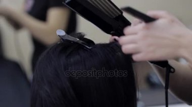 Bir Kuaför saç siyah saç düzleştirme Close-Up ütüler.