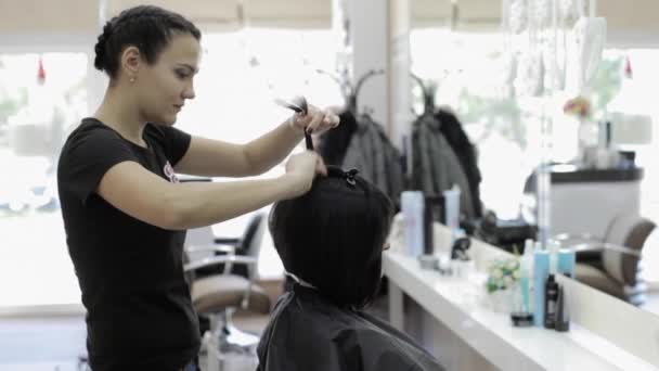 Peluquería hacer un estilo de pelo para su cliente femenino — Vídeo de stock