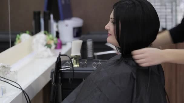 Haurdresser acaba de terminar de trabajar en la cabeza de los clientes en la peluquería — Vídeo de stock